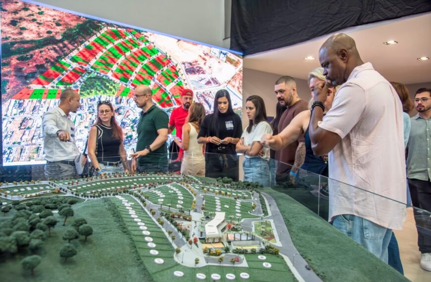 Foto de convidados observando a maquete do empreendimanto imobili«ario.